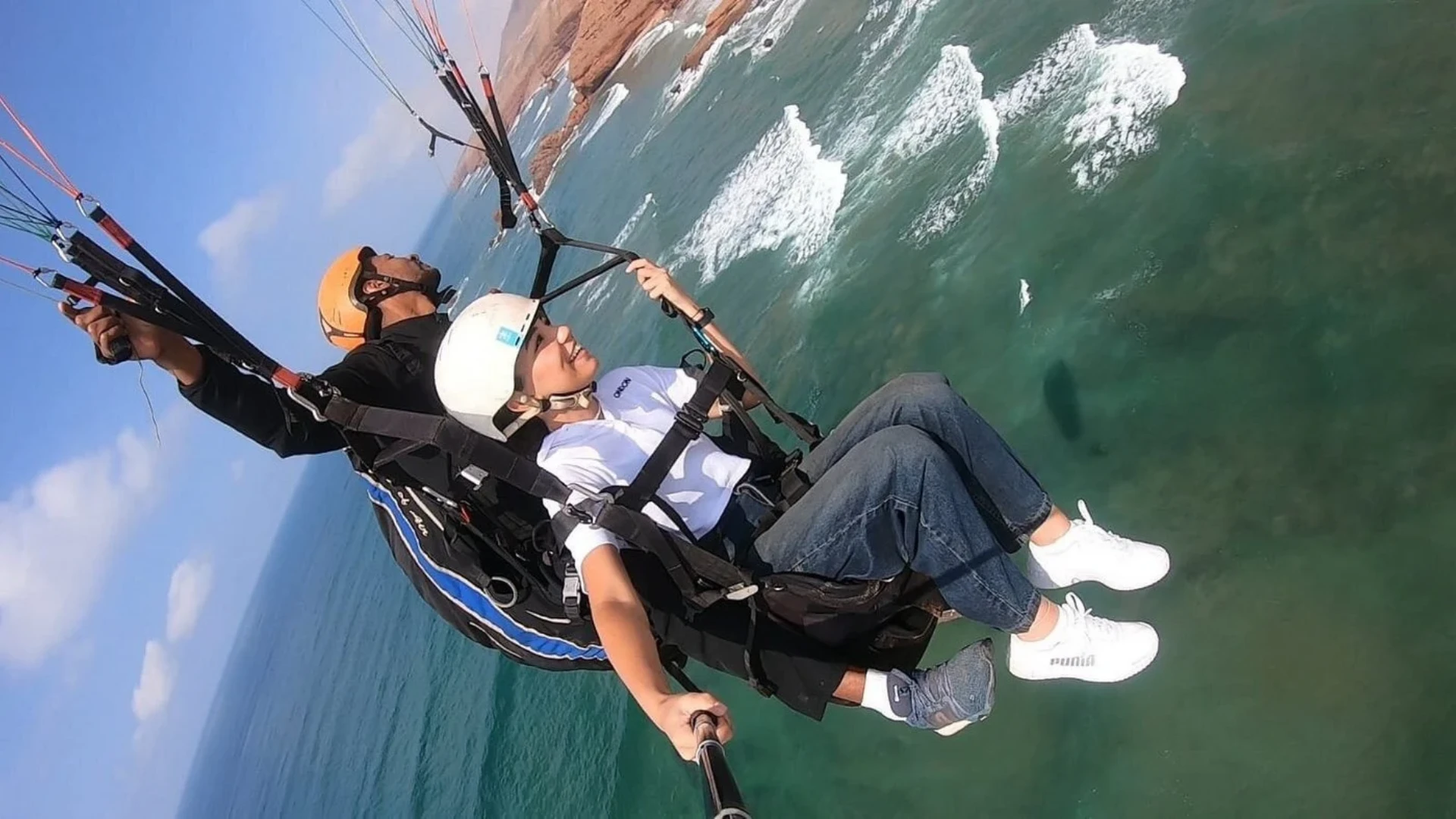 Paragliding above the sandstone arches and beach of the southern coast